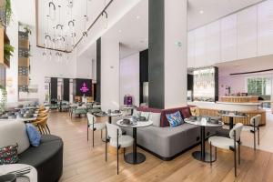 een restaurant met banken, tafels en stoelen bij YOTEL Porto in Porto