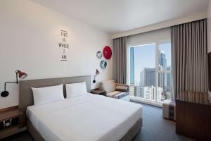 una camera d'albergo con un letto e una grande finestra di Rove Trade Centre a Dubai