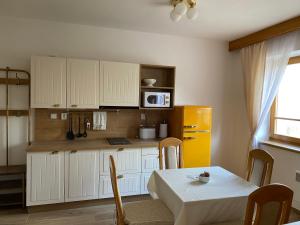 a kitchen with a table and a yellow refrigerator at Samoobslužný hotel Vydra in Srní