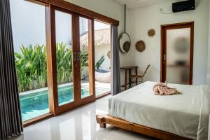 - une chambre avec un lit et une vue sur la piscine dans l'établissement KIKI VILLAGE PADDY FIELD, à Canggu