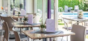 uma fila de mesas com plantas sobre elas num restaurante em Smart-HOTEL MINUSIO, a Benvenuti Hotel em Locarno