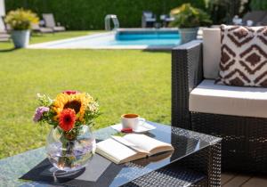 uma mesa de vidro com um vaso de flores e um livro em Smart-HOTEL MINUSIO, a Benvenuti Hotel em Locarno