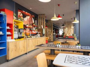 um restaurante de fast food com mesas e cadeiras em ibis Geneve Centre Lac em Genebra