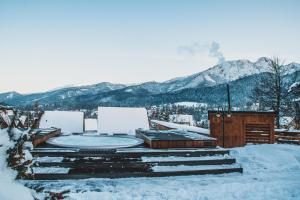 un edificio con bañera de hidromasaje en la nieve en Tatra Resort & SPA, en Kościelisko