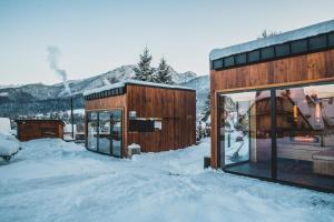 una casa en la nieve con montañas en el fondo en Tatra Resort & SPA, en Kościelisko