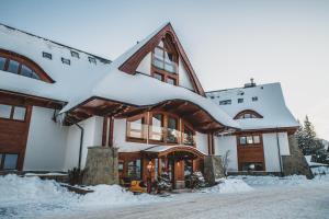 una casa cubierta de nieve con nieve en Tatra Resort & SPA, en Kościelisko