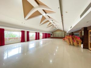 um quarto grande com cadeiras e cortinas vermelhas em Haveli Backwater Resort em Alappuzha