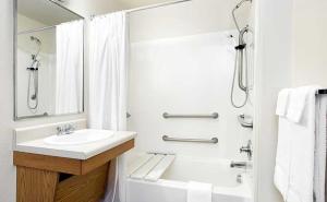 een witte badkamer met een wastafel en een douche bij WoodSpring Suites Clarksville Ft. Campbell in Clarksville