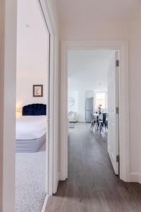 1 dormitorio blanco con 1 cama y comedor en Boutique Vertigo Apartment Central Kingston/London, en Kingston upon Thames