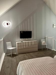 1 dormitorio con 1 cama y TV en la pared en Hôtel Le Château Fort de Sedan, en Sedan