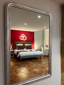 espejo que refleja un dormitorio con una pared roja en Hôtel Le Château Fort de Sedan, en Sedan