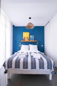 um quarto com uma cama grande e uma parede azul em La Maioneta Carré d'Or em Nice