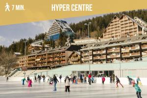 a group of people skating on an ice rink in front of a building at Plein Ciel I Balcony I Close to cable cars I Car park in Crans-Montana