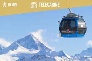 a helicopter flying over a snow covered mountain at Plein Ciel I Balcony I Close to cable cars I Car park in Crans-Montana