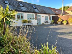 una casa con molte piante davanti di The Dairy, Bramble Farm Cottages a Ferndown