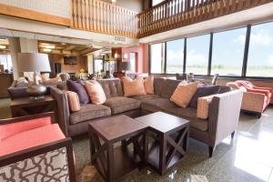 Drury Inn & Suites Jackson MO في Jackson: غرفة معيشة مع كنب وطاولات ونوافذ