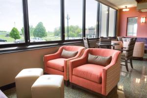 Drury Inn & Suites Jackson MO في Jackson: غرفة انتظار مع كرسيين وطاولات ونوافذ