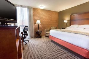 Drury Inn & Suites Jackson MO في Jackson: غرفة فندقية بسرير وتلفزيون بشاشة مسطحة