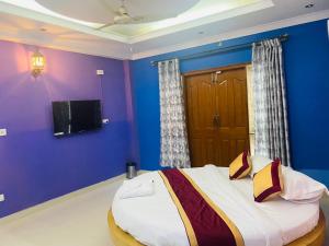 1 dormitorio con 1 cama grande y pared azul en SS Luxury Stay, en Bangalore