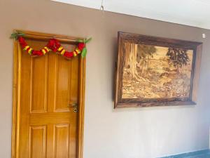 una puerta con una guirnalda de Navidad junto a una pintura en SS Luxury Stay, en Bangalore