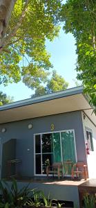 une maison avec 2 bancs sur la terrasse couverte à l'avant dans l'établissement KuadKhonThoe Pai Cottage, à Pai