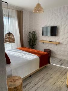 um quarto com uma cama e uma televisão na parede em Huzurla otel em Izmir