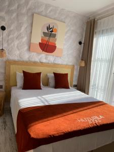 um quarto com uma cama com um cobertor laranja em Huzurla otel em Izmir