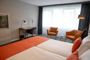 Cette chambre comprend un lit, un bureau et des chaises. dans l'établissement Hotel Restaurant Eeserhof, à Ees