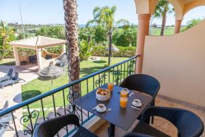 d'une table et de chaises sur un balcon avec vue sur la cour. dans l'établissement Atalaia Sol Aparthotel - tennis & heated pool in winter, à Lagos