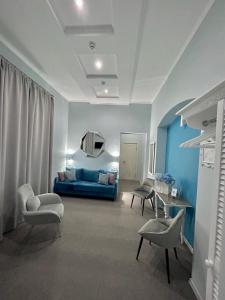 uma sala de estar com um sofá azul e cadeiras em Family Residence Boutique Hotel em Lviv