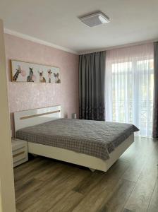 - une chambre avec un lit et une grande fenêtre dans l'établissement Mint Apartment Солнечное Закарпатье, à Polyana