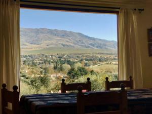 una camera da letto con una grande finestra con vista sulle montagne di Lindísima Casa en Tafí del Valle a Tafí del Valle