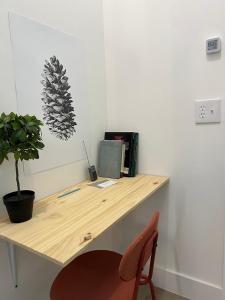 a wooden desk with a chair and a potted plant at East Harlem Hostel in New York