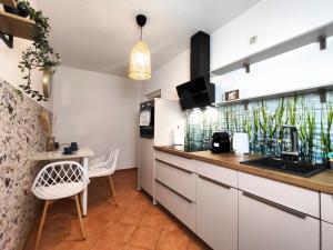 a kitchen with white cabinets and a table and chairs at BohnApartments Juwel am See, mitten in der Natur - gratis Parkplatz - Kamin - WLAN - Nähe Erfurt in Kranichfeld