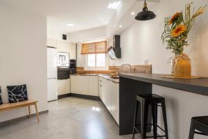 a kitchen with white cabinets and a black counter top at VILLA WINE & BEACH Design and Luxury in Cala Crancs in Salou