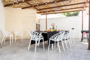 a dining room with a black table and white chairs at VILLA WINE & BEACH Design and Luxury in Cala Crancs in Salou