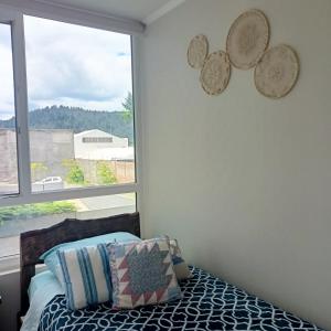 een slaapkamer met een bed en een raam bij Acogedor departamento a pasos del centro de Temuco in Temuco