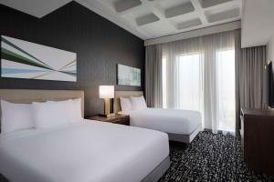 a hotel room with two beds and two windows at Hyatt House LAX Century Blvd in Los Angeles