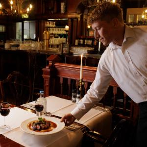 um chef a preparar um prato de comida num restaurante em Parkhotel Mastbosch Breda em Breda