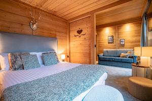 een slaapkamer met een groot bed en een bank bij Le Chalet d'Antoine - Centre de Megève in Megève