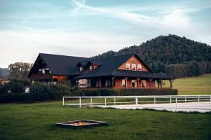 uma casa grande com um telhado preto num campo em Hotel U Pekaře - Jítravský Dvorec em Rynoltice