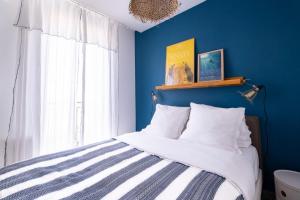 um quarto azul com uma cama e uma janela em La Maioneta Carré d'Or em Nice