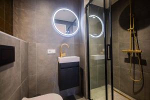 een badkamer met een douche, een wastafel en een spiegel bij Luxurious 35m2 Designer Studio in Eindhoven