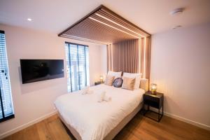 een slaapkamer met een wit bed met 2 kussens bij Luxurious 35m2 Designer Studio in Eindhoven