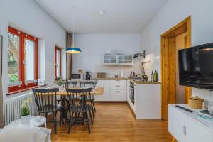 cocina y comedor con mesa y sillas en Apartments Kassebohmer Weg, en Rostock