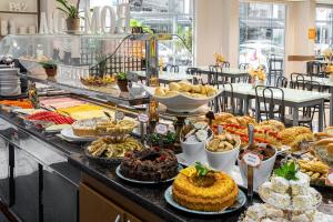 un buffet con muchos tipos diferentes de postres y pasteles en Hotel Negrini, en Balneário Camboriú