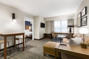 Residence Inn Houston The Woodlands/Market Street في ذا وودلاندس: جناح في الفندق مع غرفة معيشة وغرفة نوم