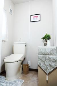 uma casa de banho branca com um WC e uma mesa em TORII room em Kumamoto