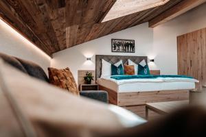 ein Schlafzimmer mit einem Bett und einem Stuhl in der Unterkunft Tanners Chalet Apartments in Altenmarkt im Pongau