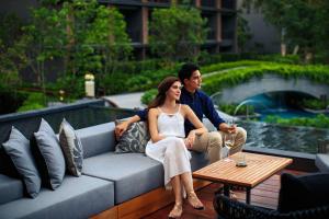 um homem e uma mulher sentados num sofá em Hua Hin Marriott Resort and Spa em Hua Hin